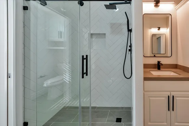 a bathroom with a shower sink and mirror