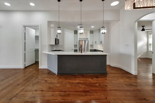 a kitchen with kitchen island a sink and a refrigerator