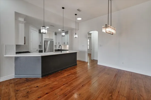 a view of a kitchen with wooden floor and chandelier