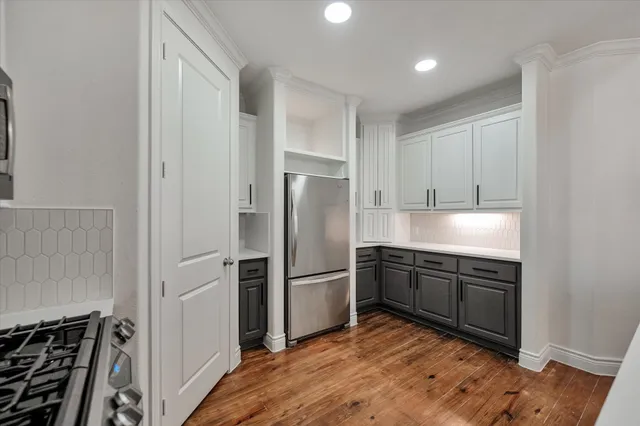 a kitchen with stainless steel appliances granite countertop a refrigerator and a stove top oven