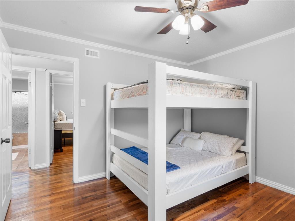 1318 Brook Valley Lane Dallas, TX 75232 - Photo 11 of 39 a bedroom with a bed and a chandelier fan