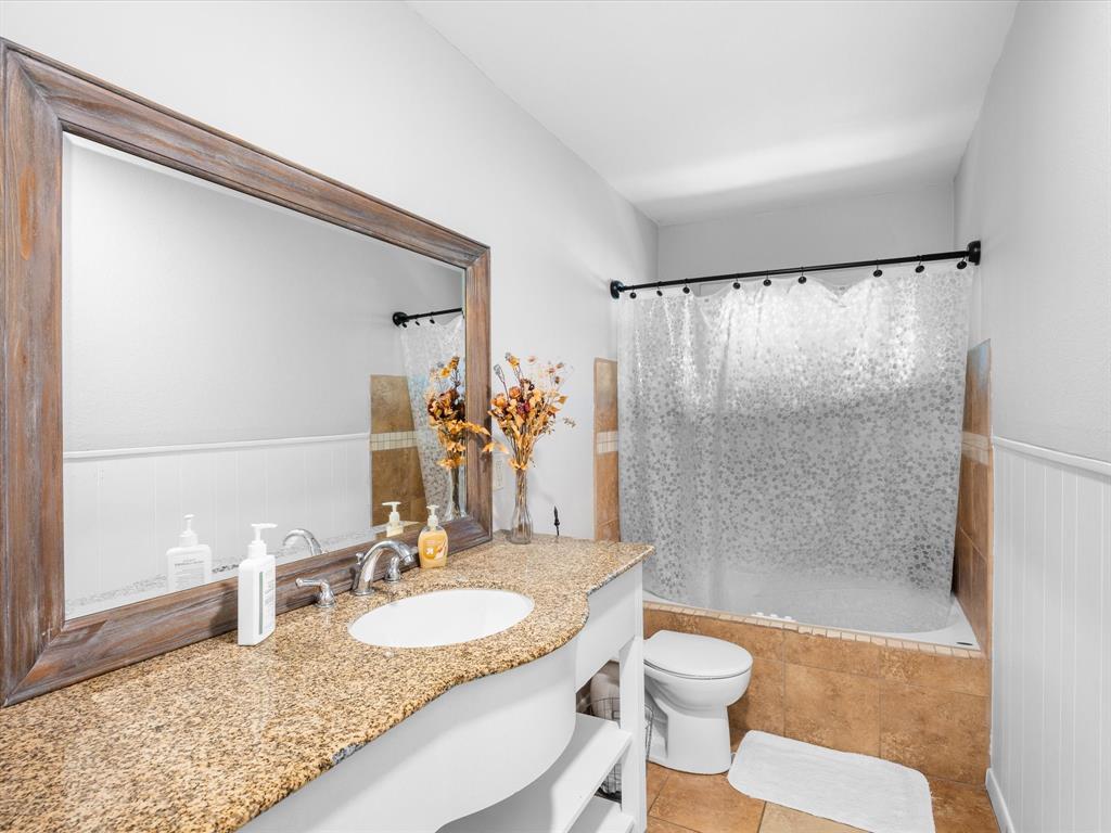 1318 Brook Valley Lane Dallas, TX 75232 - Photo 12 of 39 a bathroom with a granite countertop sink toilet and shower