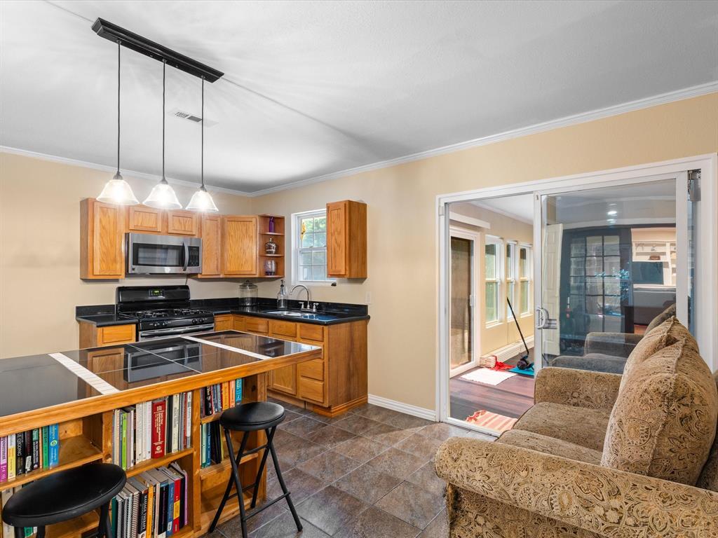 1318 Brook Valley Lane Dallas, TX 75232 - Photo 15 of 39 a living room with furniture a ceiling fan and a book shelf