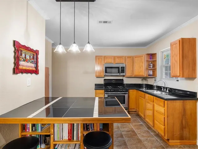 a kitchen with stainless steel appliances a stove a sink and a microwave