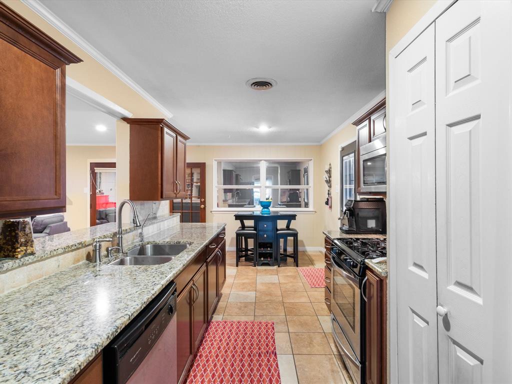 1318 Brook Valley Lane Dallas, TX 75232 - Photo 28 of 39 a kitchen with counter top space a sink a refrigerator and cabinets
