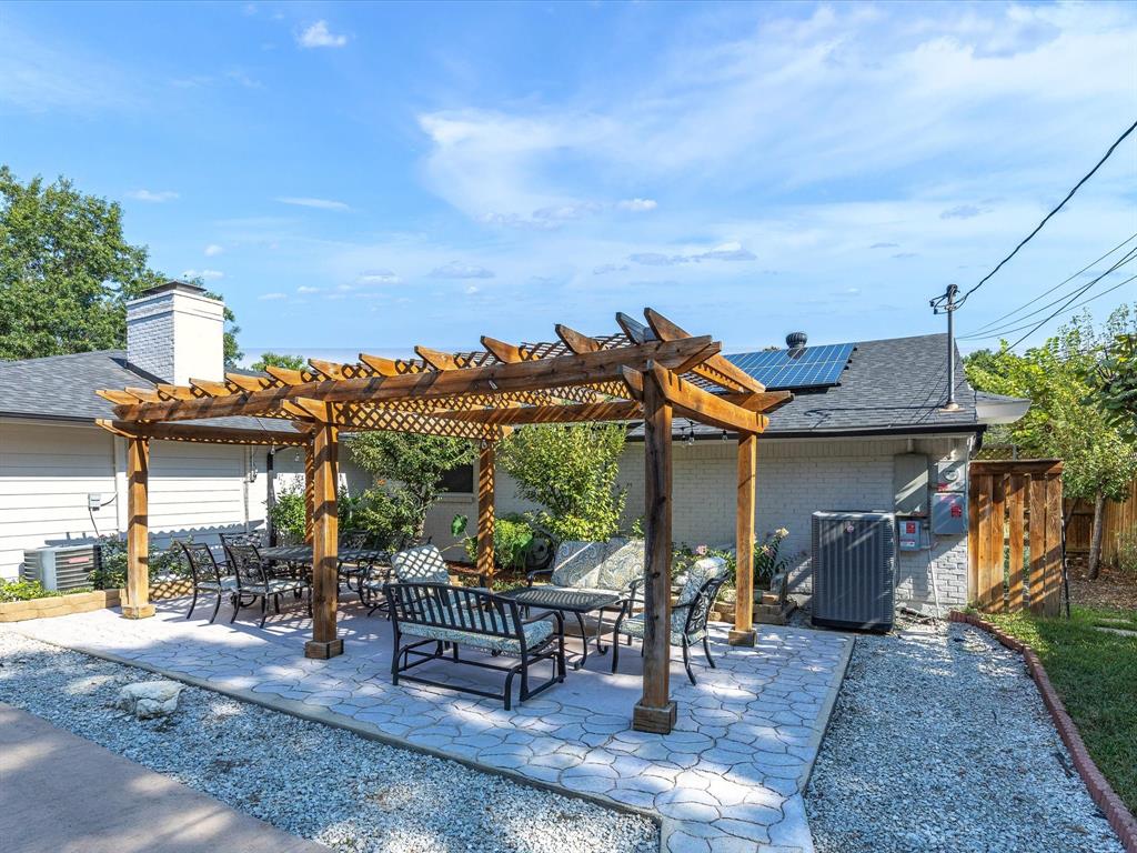 1318 Brook Valley Lane Dallas, TX 75232 - Photo 33 of 39 a view of a patio with table and chairs potted plants and palm tree
