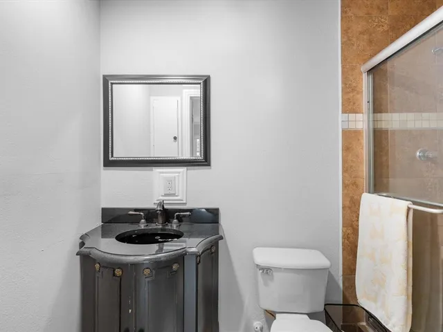 a bathroom with a toilet a sink and mirror