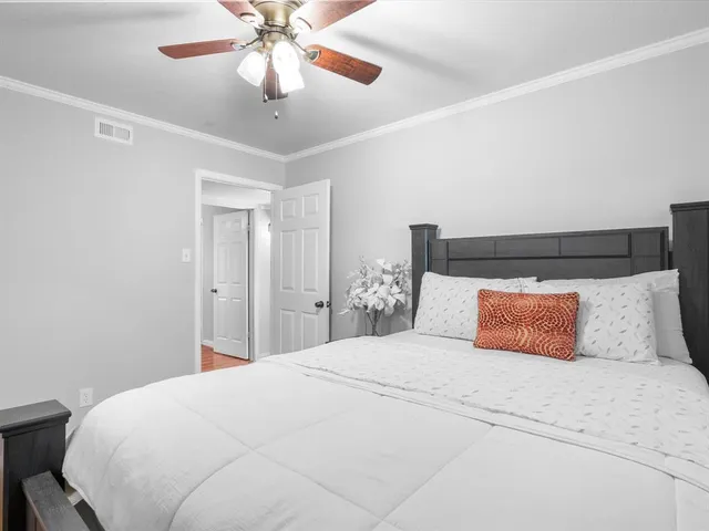 a bedroom with a large bed and a chandelier