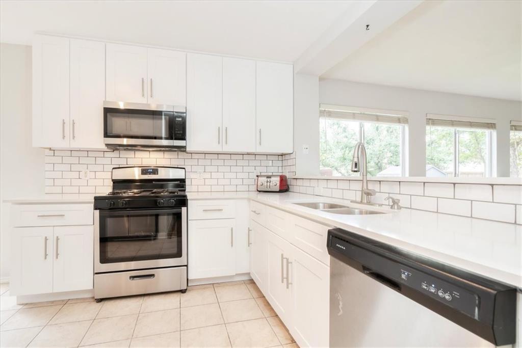 20805 Jumpers Delight Lane Pflugerville, TX 78660 - Photo 11 of 24 Kitchen featuring stainless steel appliances, white cabinets, light stone countertops, light tile patterned floors, and tasteful backsplash