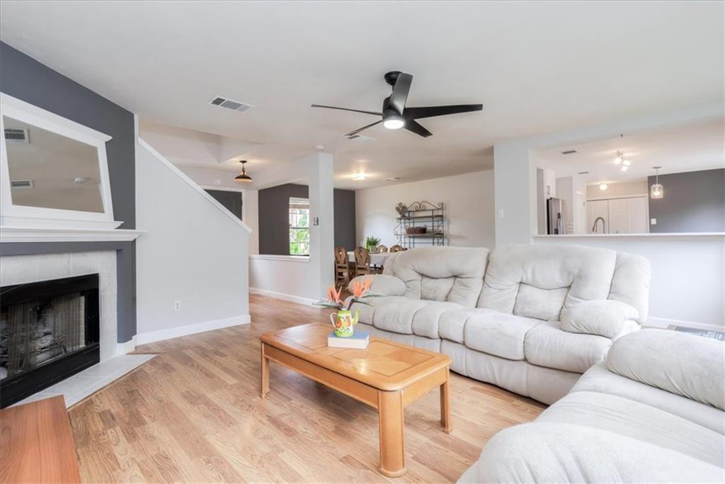 20805 Jumpers Delight Lane Pflugerville, TX 78660 - Photo 3 of 24 Living room featuring wood finished floors, a tile fireplace, and a ceiling fan