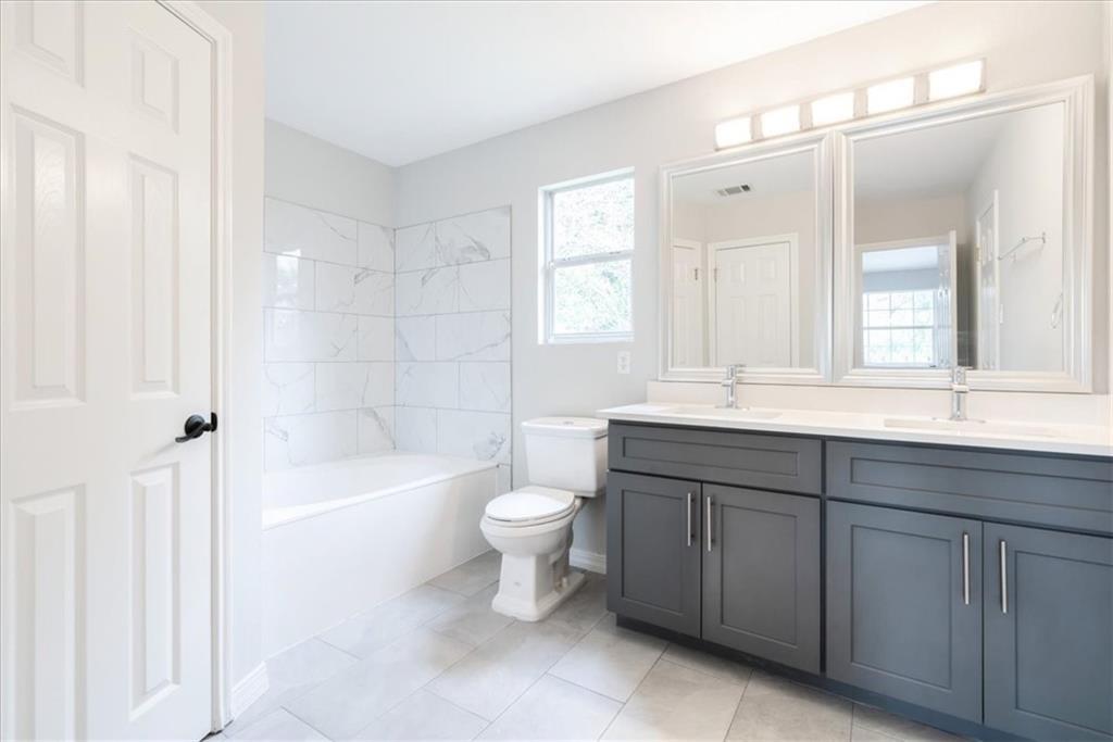 20805 Jumpers Delight Lane Pflugerville, TX 78660 - Photo 4 of 24 Full bath with double vanity, bathing tub / shower combination, and light tile patterned floors