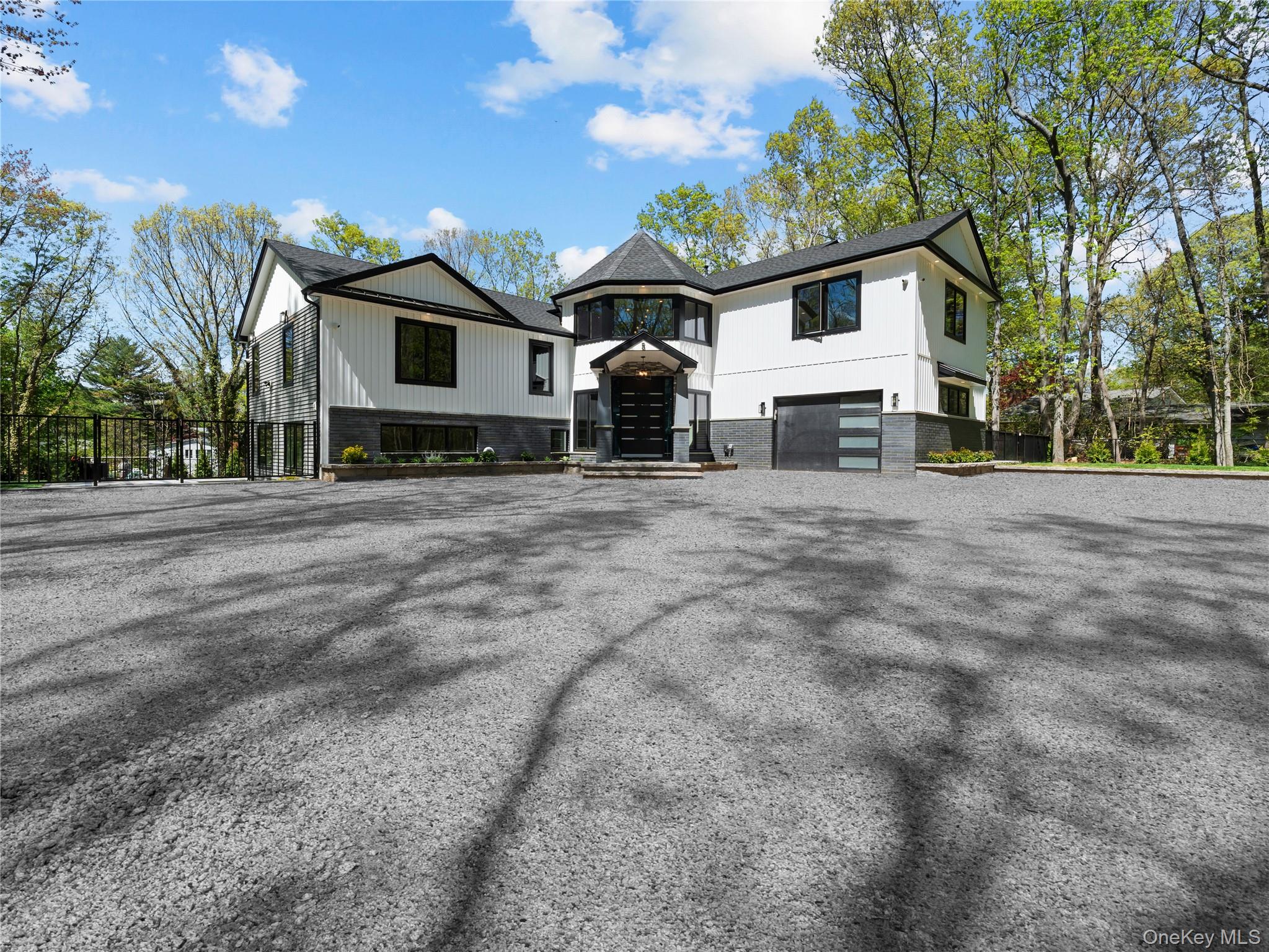 a front view of a house with a dirt yard and a large tree