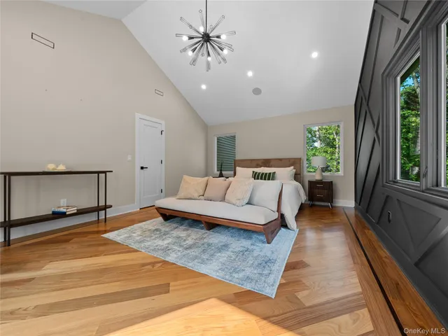 a living room with large couches and a dining table with wooden floor