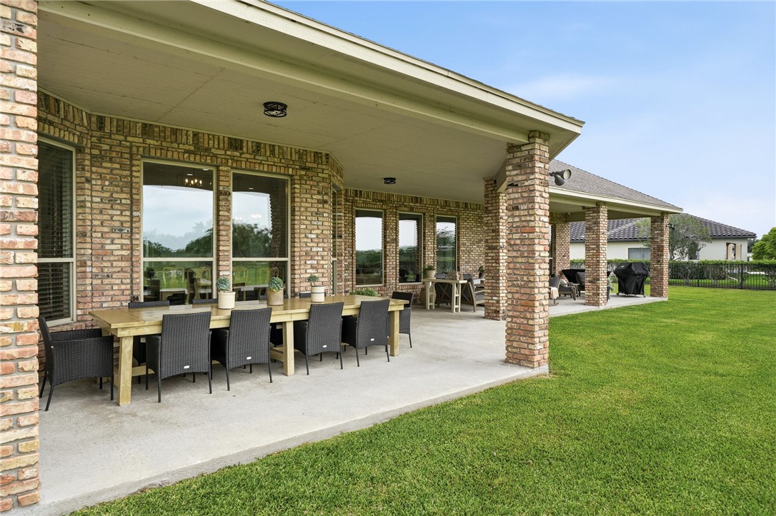 8710 KIng Ranch Drive Corpus Christi, TX 78414 - Photo 24 of 38 a view of a patio with table and chairs potted plants and floor to ceiling window