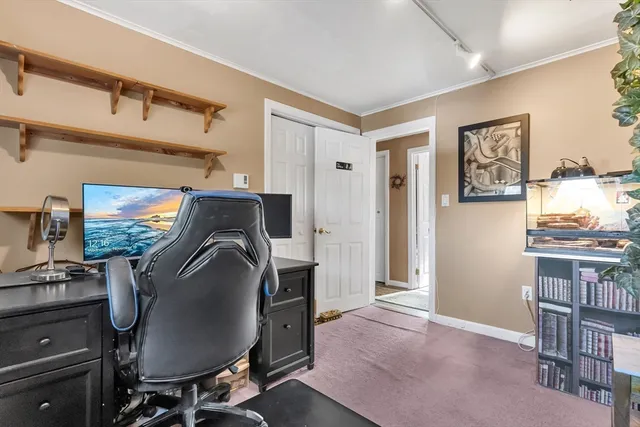 a workspace with furniture a flat screen tv and a window