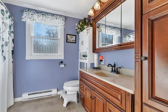 a bathroom with a sink a toilet and a window