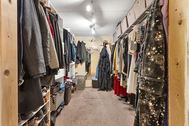 a view of walk in closet with clothes
