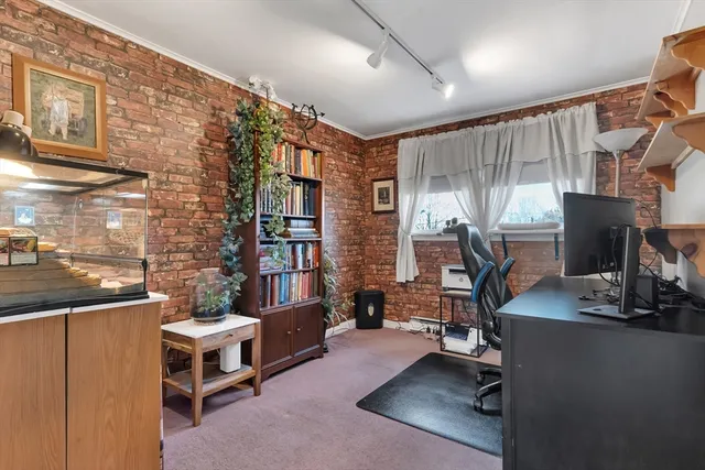 a view of a livingroom with workspace and a window