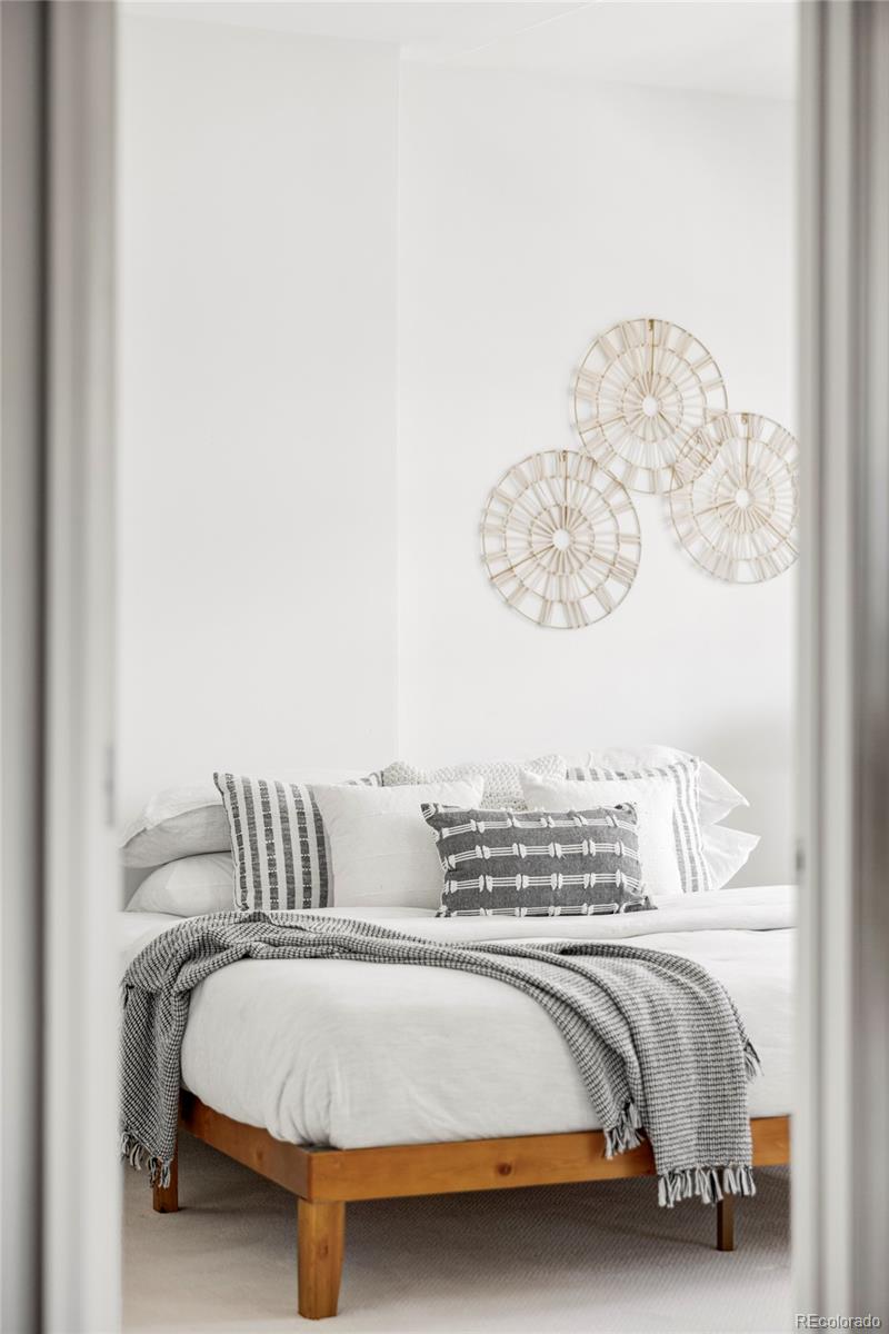 1950 Logan Street, Unit 1013 Denver, CO 80203 - Photo 12 of 23 a bedroom with a bed and lamp