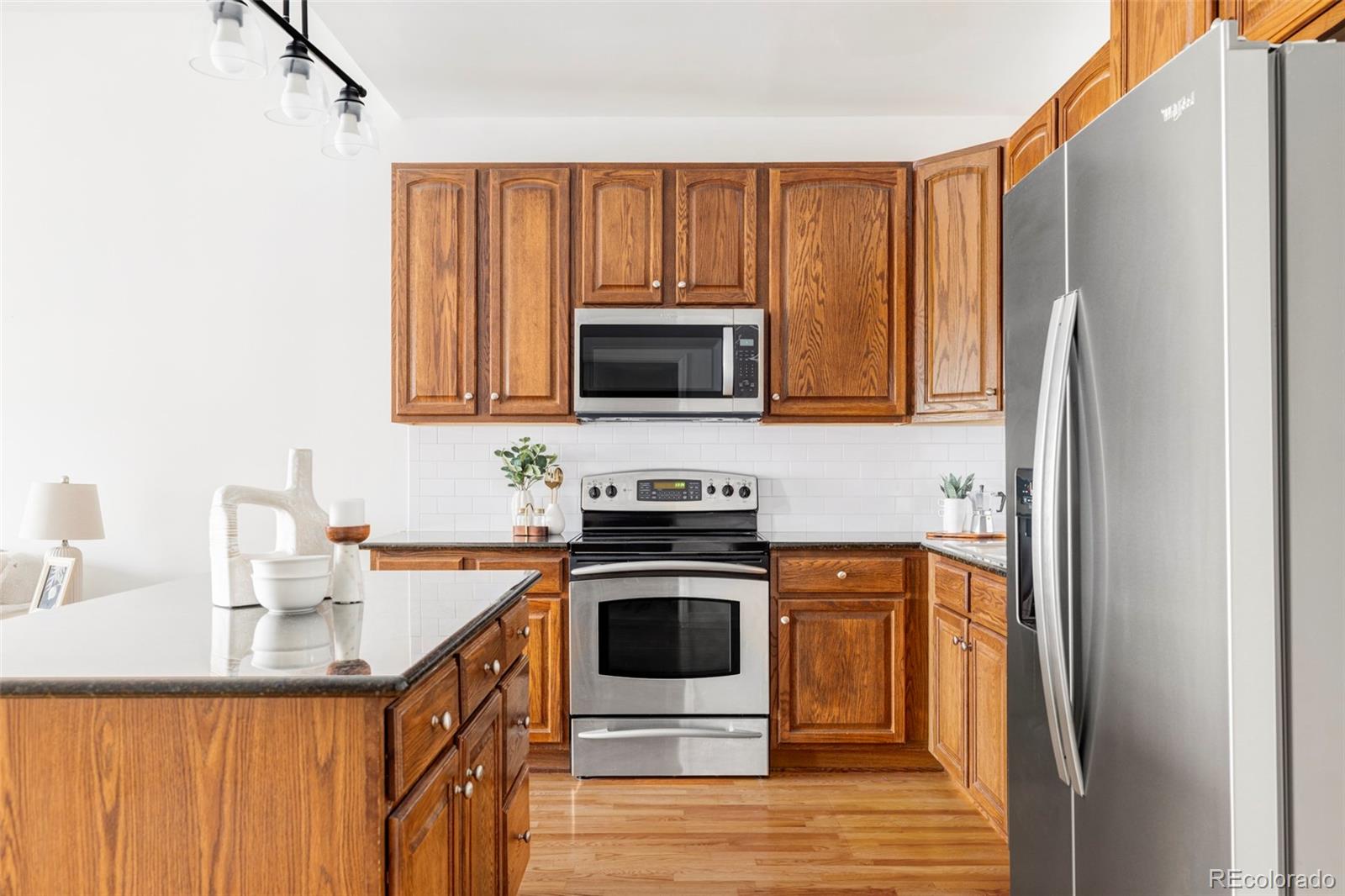 1950 Logan Street, Unit 1013 Denver, CO 80203 - Photo 6 of 23 a kitchen with a stove a sink and a microwave
