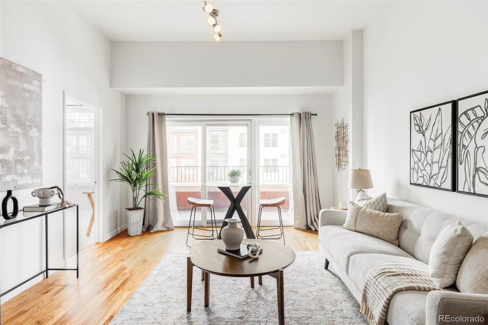 1950 Logan Street, Unit 1013 Denver, CO 80203 - Photo 9 of 23 a living room with furniture potted plant and large windows