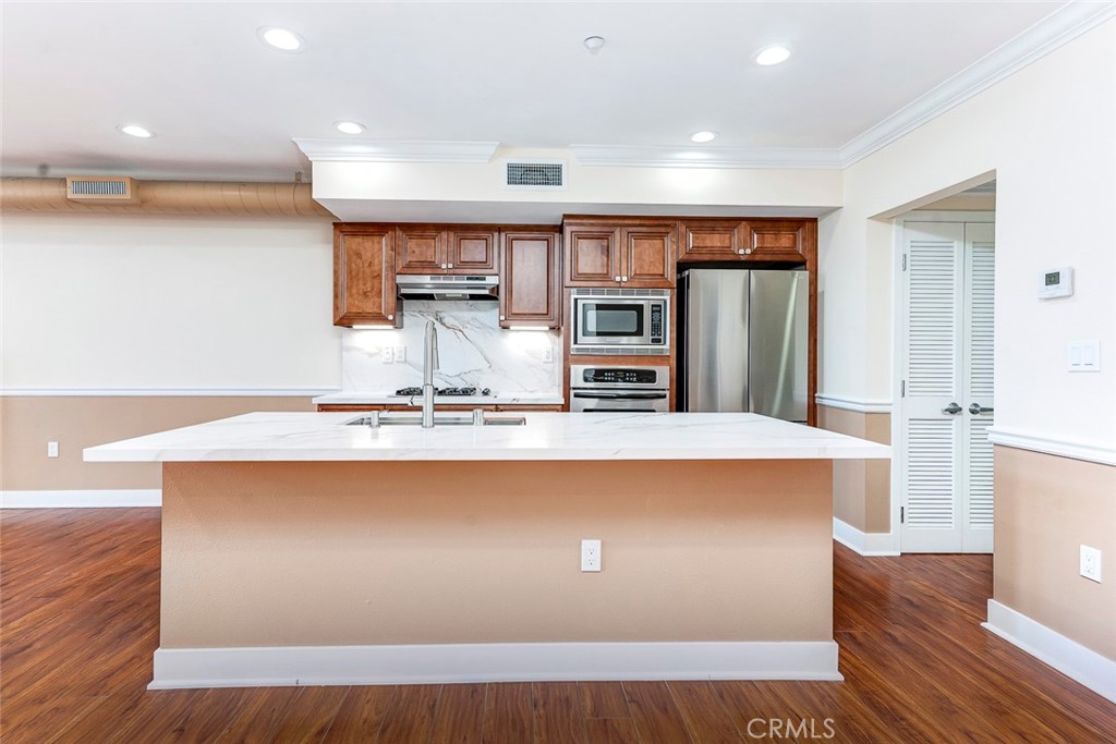 596 South Brea Boulevard Brea, CA 92821 - Photo 11 of 33 a large kitchen with stainless steel appliances a large counter top a stove a refrigerator and a cabinets