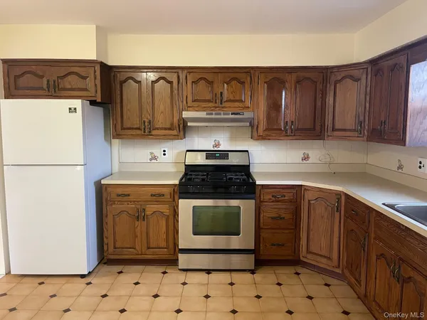 a kitchen with stainless steel appliances granite countertop a stove a refrigerator and a sink