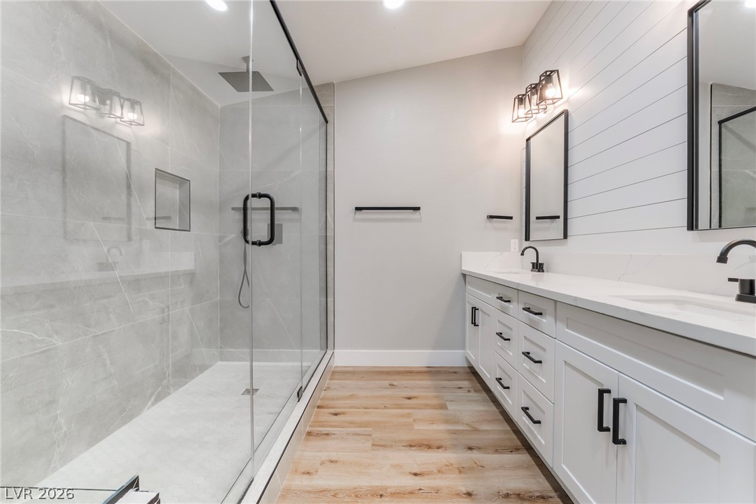 9171 West Viking Road Las Vegas, NV 89147 - Photo 34 of 43 A sleek, contemporary bathroom features a spacious glass-enclosed shower and a dual vanity with light countertops.