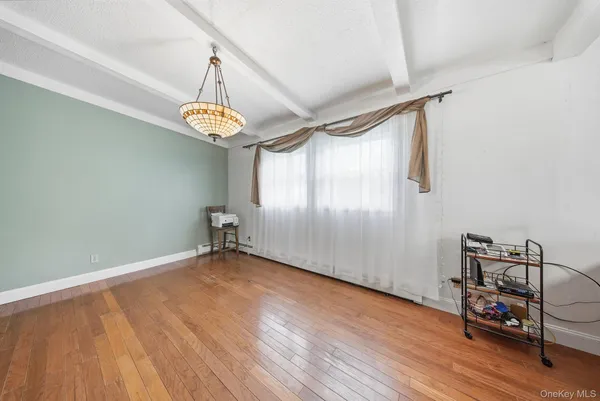 a view of a room with wooden floor table and chairs
