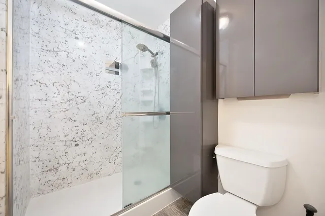 a white toilet sitting next to a bath tub shower
