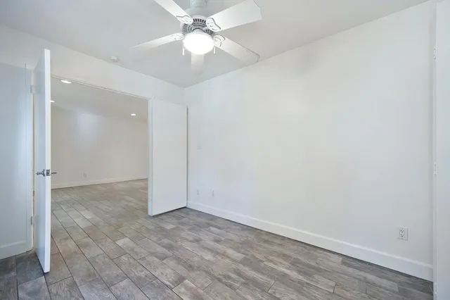an empty room with a ceiling fan and a bathroom