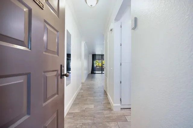 a view of a hallway with wooden floor and staircase