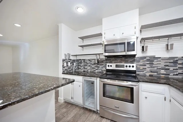 a kitchen with stainless steel appliances granite countertop a stove and a microwave