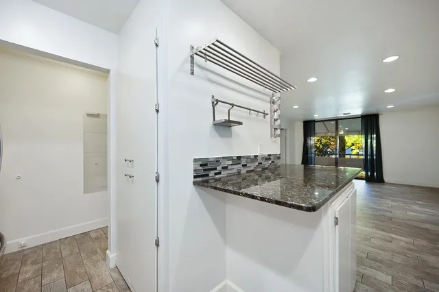 a kitchen with stainless steel appliances granite countertop a sink and a refrigerator