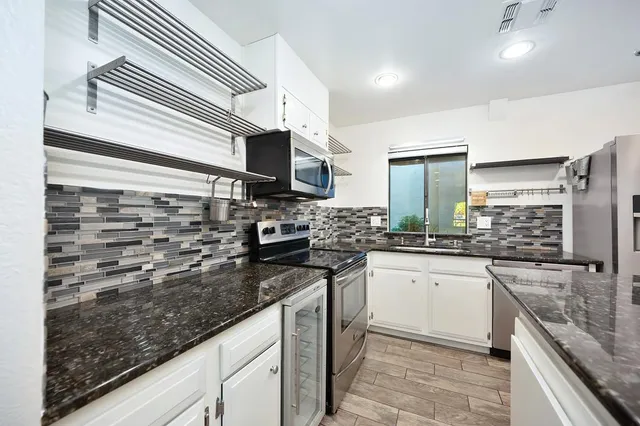 a kitchen with stainless steel appliances granite countertop a sink stove and refrigerator
