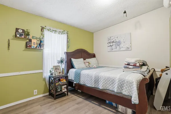 a living room with furniture kitchen view and a wooden floor