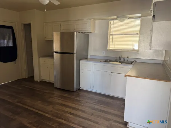a kitchen with a refrigerator sink and cabinets