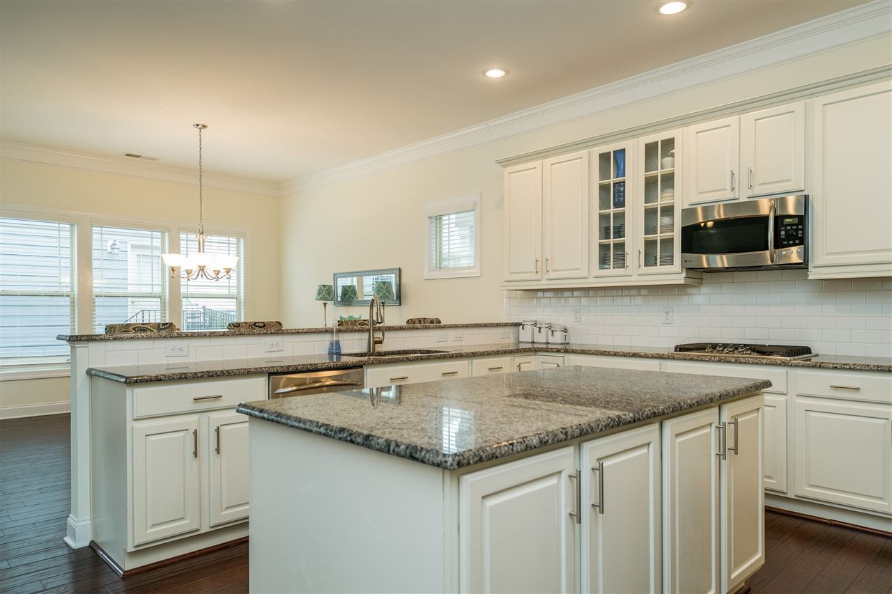 5616 Wade Park Boulevard Raleigh, NC 27607 - Photo 8 of 30 Dream kitchen features granite counters, two ovens, gas range, stainless appliances, white subway tile backsplash, huge island, bar, and tons of cabinet space! Kitchen
