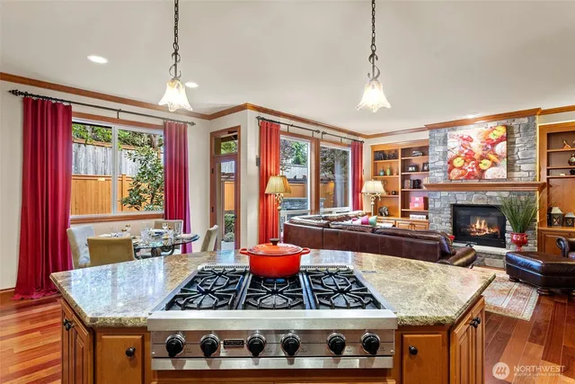 a kitchen with a stove a sink a refrigerator and wooden floor