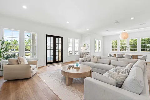 a kitchen with stainless steel appliances a table chairs wooden floors and a view of living room