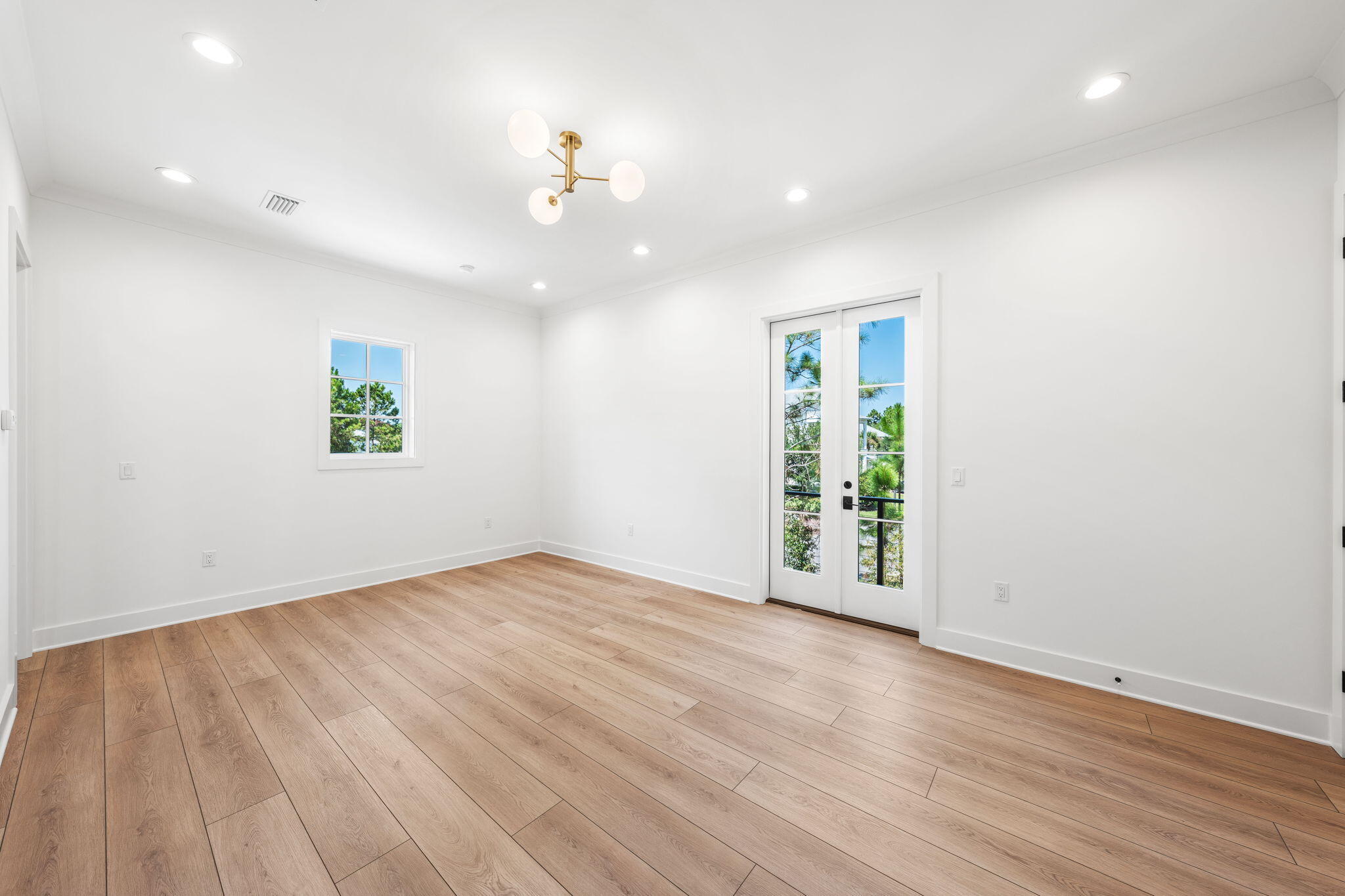 181 Plantation Circle Santa Rosa Beach, FL 32459 - Photo 52 of 69 an empty room with wooden floor chandelier and windows