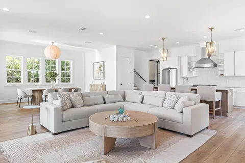 a kitchen that has a lot of cabinets in it and wooden floors