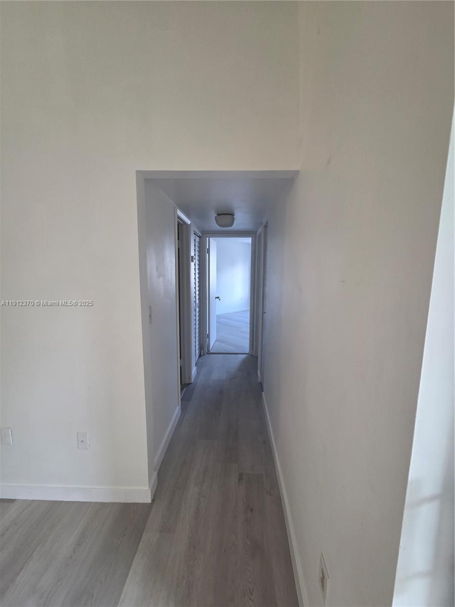 9433 Fontainebleau Boulevard, Unit 212 Miami, FL 33172 - Photo 13 of 45 a view of a hallway with wooden floor