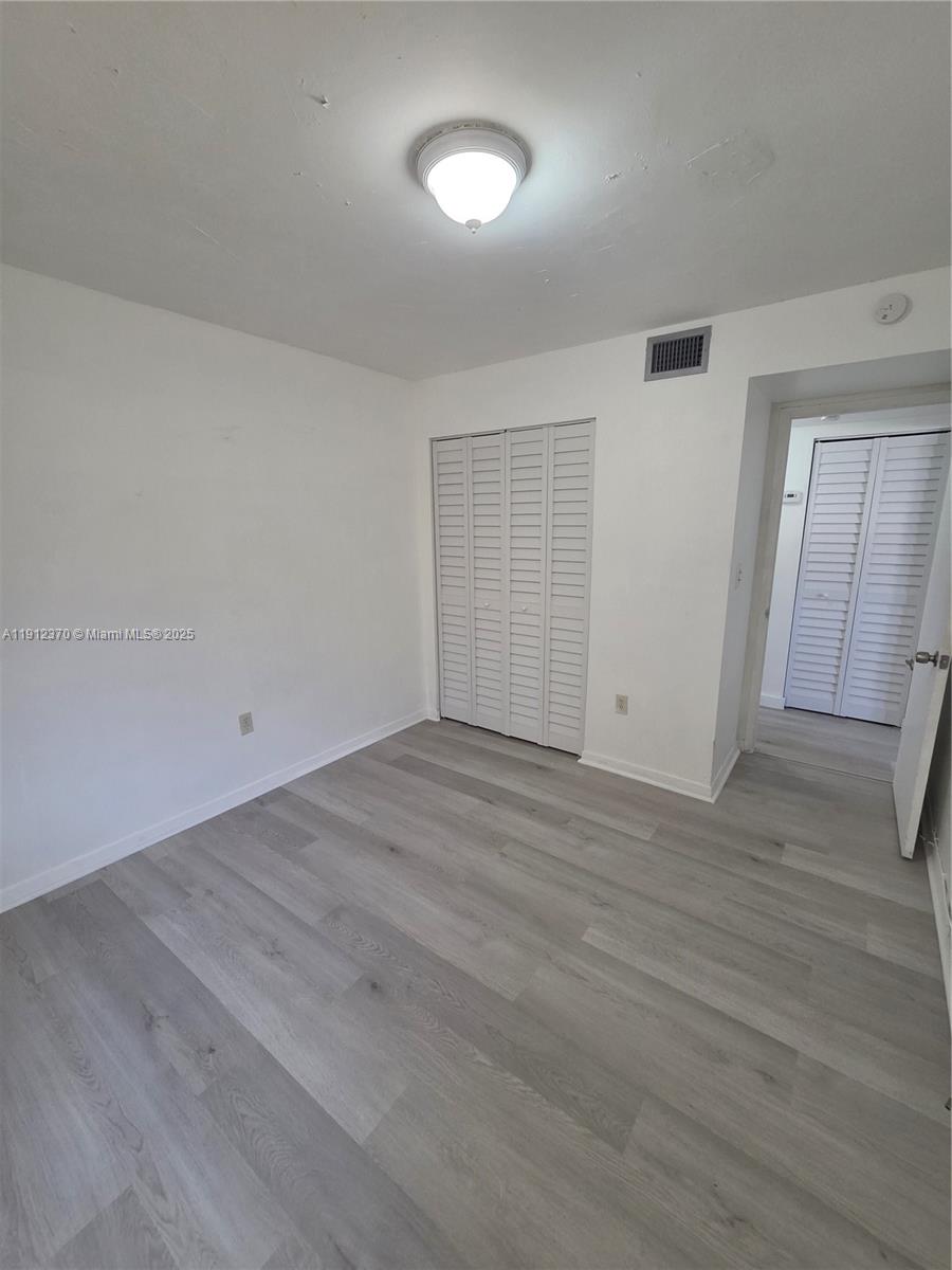 9433 Fontainebleau Boulevard, Unit 212 Miami, FL 33172 - Photo 23 of 45 wooden floor in an empty room