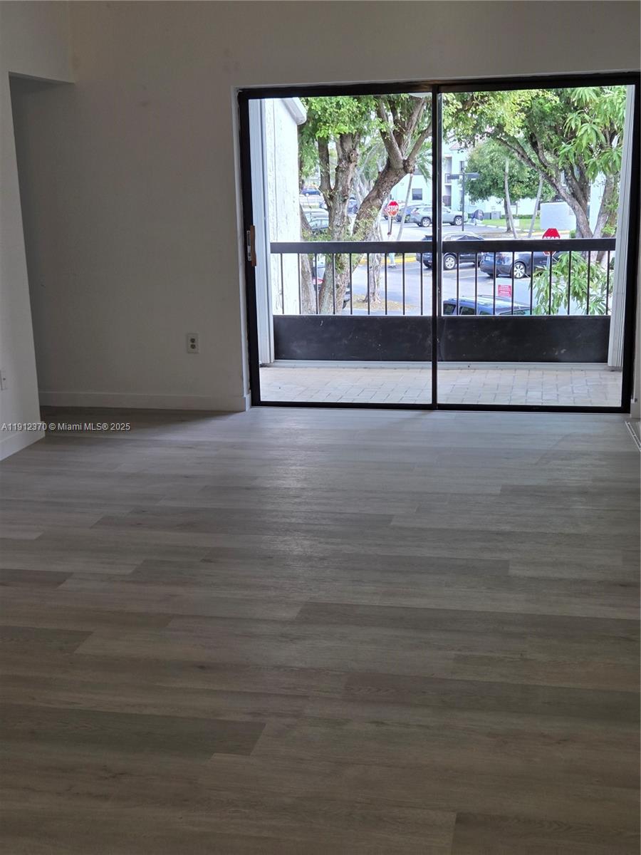 9433 Fontainebleau Boulevard, Unit 212 Miami, FL 33172 - Photo 3 of 45 a view of wooden floor and windows in an empty room