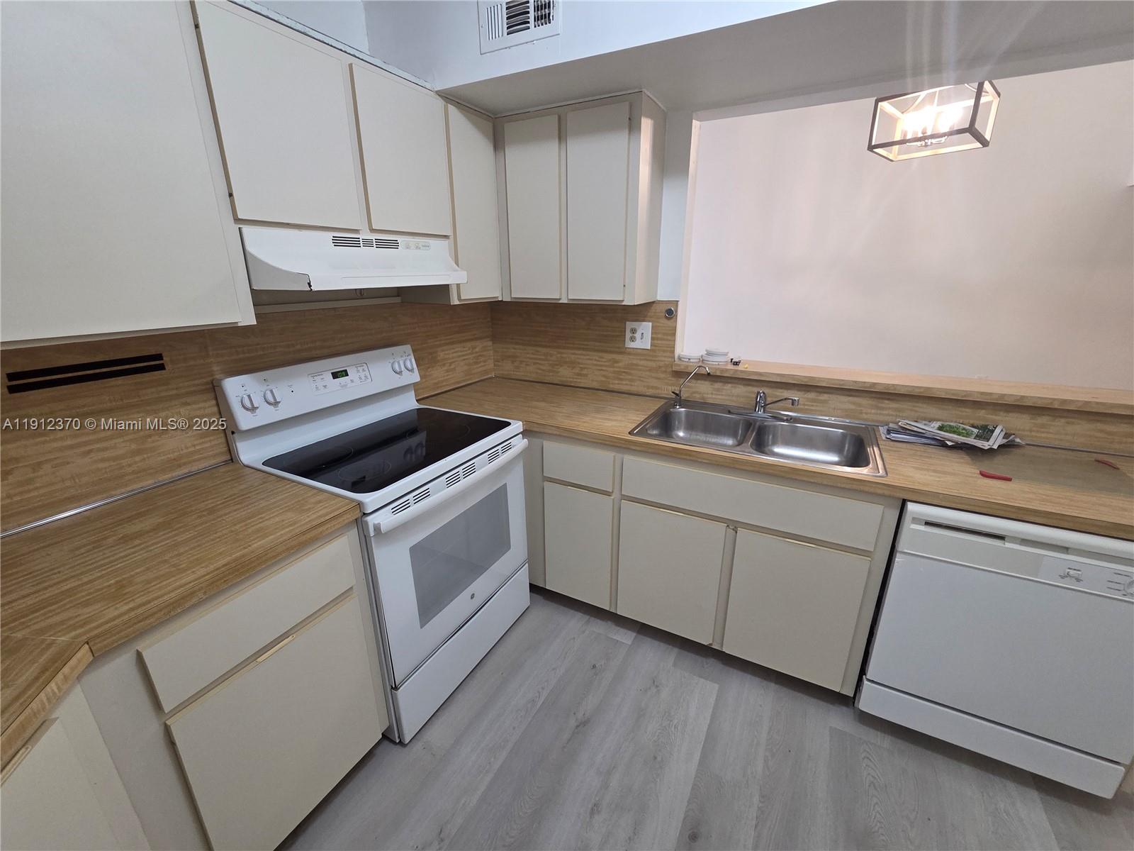 9433 Fontainebleau Boulevard, Unit 212 Miami, FL 33172 - Photo 5 of 45 a kitchen with white cabinets and white appliances