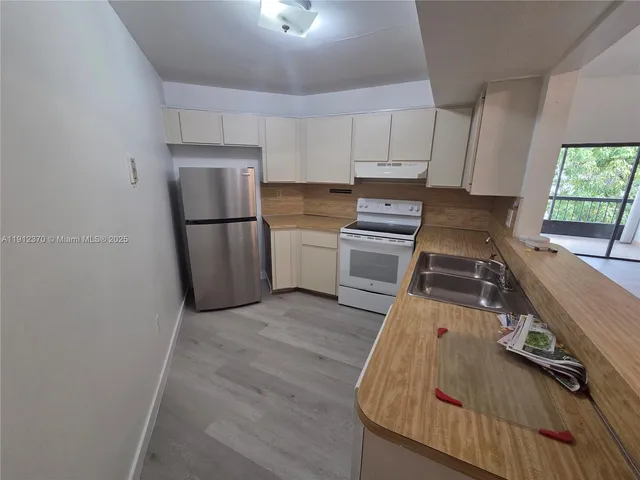 a kitchen with a refrigerator sink and stove