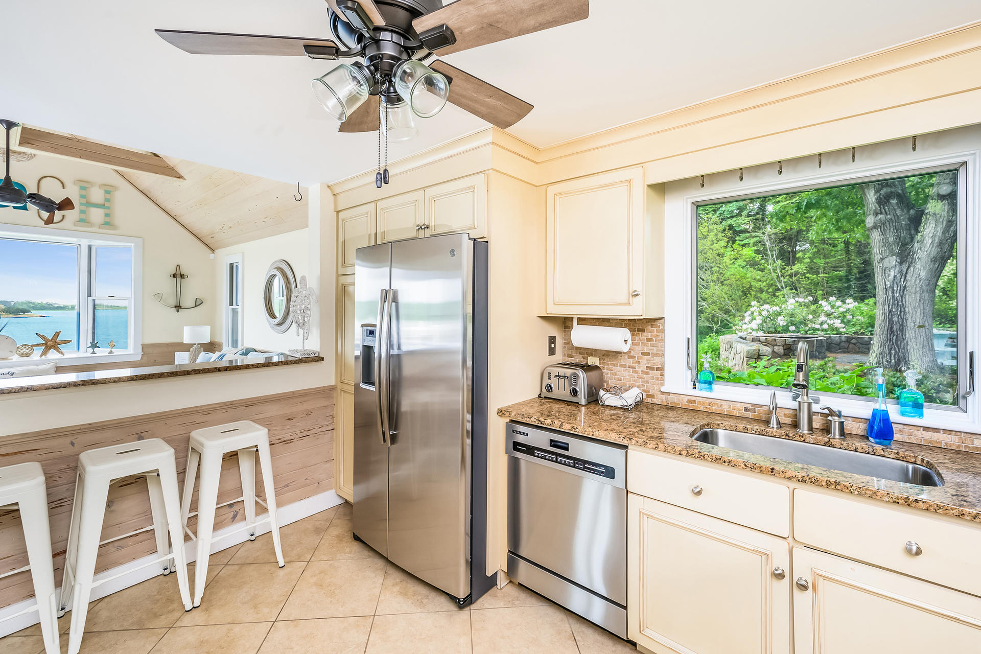 33 Ruggles Road Orleans, MA 02653 - Photo 19 of 80 a kitchen with granite countertop a center island stainless steel appliances cabinets and a large window