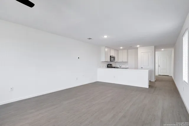 a view of kitchen with kitchen island wooden floor center island and stainless steel appliances