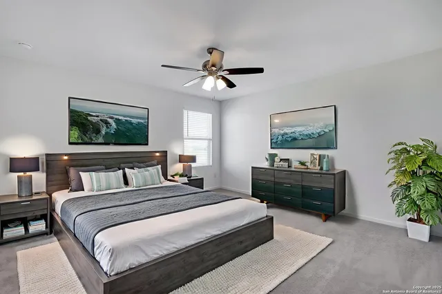 a bedroom with a bed a chandelier and a dresser